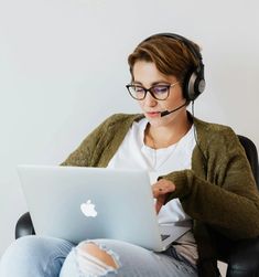 a woman wearing headphones and using a laptop