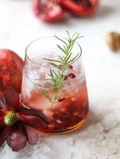 pomegranate and rosemary garnish in a glass with ice