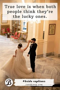 a bride and groom holding hands in the middle of a room with chandelier