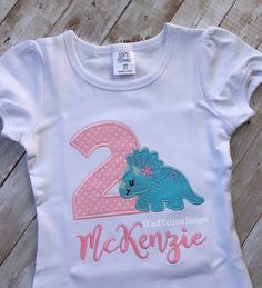 Dinosaur Birthday Shirt, Girl Dinosaur Birthday Top, Personalized Birthday Shirt, Girl Birthday Party Outfit, Dino Birthday Shirt, Embroidered Shirt PROCESSING TIME IS 2-3 weeks NOT INCLUDING SHIPPING. If needed sooner please message me and I will do my best to accommodate your request. Processing time does not include shipping which is USUALLY an additional 2-6 days with First Class shipping. This shirt is a dinosaur and number appliqué with the option to add a name. The design on the shirt is Summer Dinosaur Print Top For Birthday, Summer Birthday Tops With Dinosaur Print, Summer Birthday Top With Dinosaur Print, Dinosaur Print Tops For Summer Birthday, Birthday Dinosaur Print Short Sleeve Top, Dinosaur Print Short Sleeve Top For Birthday, Cotton Dinosaur Print Top, Cotton Top With Dinosaur Print For Birthday, Dino Birthday Shirt