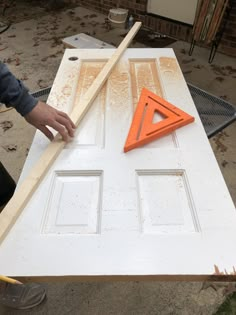 a man is working on an unfinished door with wood and plastic triangle shaped pieces attached to it