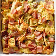 a casserole dish with ham, cheese and bread toppings in a white baking dish