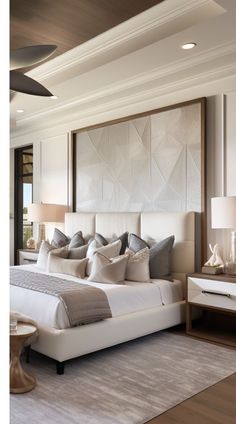 a large white bed sitting inside of a bedroom next to a tall ceiling fan on top of a hard wood floor