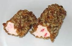 two pieces of food on a white plate with pink cream and crumbled toppings