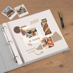 an open planner book sitting on top of a wooden table next to a pen and pencil