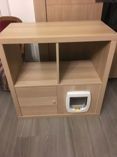 a dog door is open in front of a wooden entertainment center with drawers and shelves