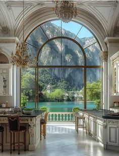 a large kitchen with an arched window overlooking a lake and mountains is pictured in this image