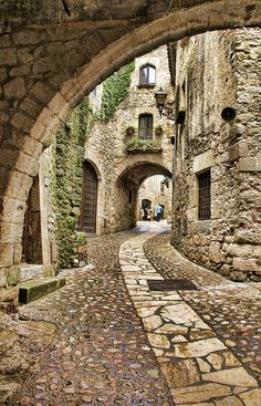 an alley way with stone buildings and cobblestones