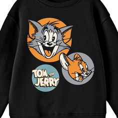 Celebrate your favorite cartoons in comfort with this Tom & Jerry sweatshirt. The sweatshirt features illustrations of Tom and Jerry in orange and in orange and gray circles while the series logo appears in a blue circle next to the characters. The sweatshirt comes in a black long sleeve crew neck. Tom & Jerry fans will love this comfy and cozy sweatshirt. Tom And Jerry Sweatshirt, Pop Culture Cartoon Print Sweatshirt For Winter, Winter Pop Culture Sweatshirt With Cartoon Print, Character Print Hoodie For Fans With Crew Neck, Cotton Cartoon Print Tops, Crew Neck Hoodie With Character Print For Fans, Fan Merchandise Hoodie With Character Print, Crew Neck, Graphic Print Orange Sweatshirt For Streetwear, Casual Cartoon Print Sweatshirt For Fans