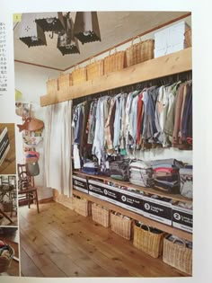 an open closet with clothes hanging on the wall and baskets full of items in it