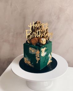 a green and gold birthday cake sitting on top of a white plate