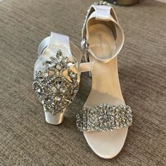 two pairs of wedding shoes sitting on top of a carpeted floor next to each other