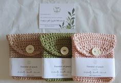 three crocheted purses with buttons on them sitting on a white tablecloth