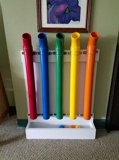 there are four different colored toothbrushes in the holder next to each other on the floor