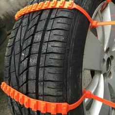 an orange tire chains are attached to the rim of a car