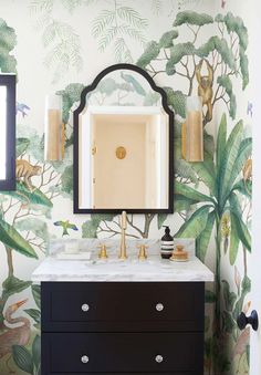 a bathroom with a mirror, sink and wallpaper