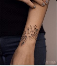 a woman with a flower tattoo on her arm