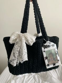 a black purse with white lace and a photo hanging from it