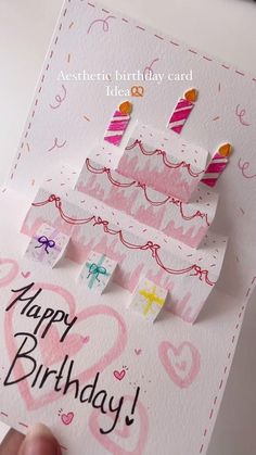 a hand holding up a birthday card with candles on it