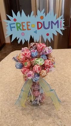 a vase filled with lollipops sitting on top of a counter next to a free sign