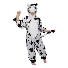 a child in a cow costume standing on one leg and holding a stick with both hands