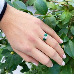 This three-stone engagement ring features an emerald-cut diamond center flanked by a pair of emerald-cut emeralds prong-set in a platinum mounting. Center Diamond Total Weight: 1.13 ct Shape: Emerald-Cut Color: F Clarity: SI1 Side Emerald Total Weight: 1.08 ct Shape: Emerald-Cut Color: bluish-green hue, medium dark tone, strong to vivid saturation Clarity: slightly included Ring Size: 7 Excluded from all discounts and promotions. Green Three Stone Emerald Cut Jewelry, Three-stone Emerald Cut Green Emerald Ring, Green Three-stone Emerald-cut Emerald Ring, Green Three Stone Emerald Cut Emerald Ring, Green Emerald Cut Three Stone Emerald Ring, Green Three Stone Baguette Cut Ring, Green Baguette Cut Three Stone Rings, Emerald Cut Three Stone Emerald Ring, Green Emerald Three Stone Diamond Ring