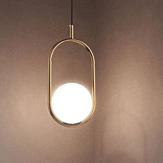 a light that is hanging from the ceiling in front of a wall with a lamp on it