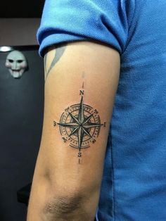 a man with a compass tattoo on his arm