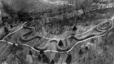 an aerial view of a track in the middle of nowhere, with trees on both sides