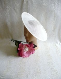 "One contoured saucer with a slight upturned brim hat sinamay straw fascinator / hat base in ivory that measures approximately 13\" in diameter. The base is contoured to fit against the head. The edges of the brim are finished in sinamay. The multi-layer stiffened sinamay straw has a great sturdy weave and provides excellent support for your millinery creations. This is NOT a finished hat and will not stay on your head unless you add a head band to wear. Add embellishments of your choice. A nice Fitted Sinamay Boater Hat With Curved Brim, Fitted Sinamay Boater Hat With Flat Brim, Cream Fitted Brimmed Sun Hat, Cream Brimmed Fitted Sun Hat, Fitted Cream Brimmed Sun Hat, Classic White Mini Hat With Curved Brim, White Classic Mini Hat With Curved Brim, White Fitted Boater Hat With Flat Brim, Classic White Mini Hat With Wide Brim