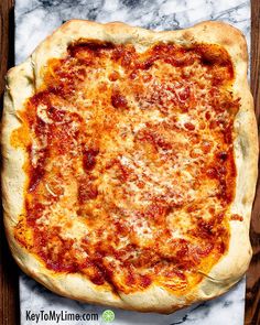 an uncooked pizza sitting on top of a wooden table