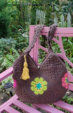 a crocheted purse sitting on top of a pink bench