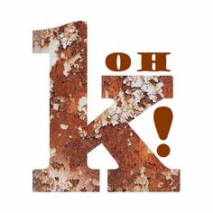 the letter k is made up of rusted metal and has an exclamation