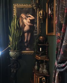 a painting hangs on the wall next to a potted plant