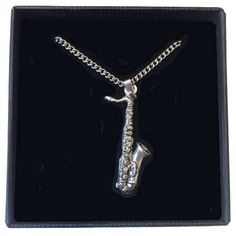 a silver saxophone necklace in a black box