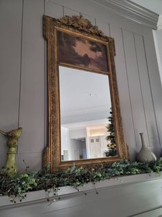 a mirror sitting on top of a mantle next to a painting