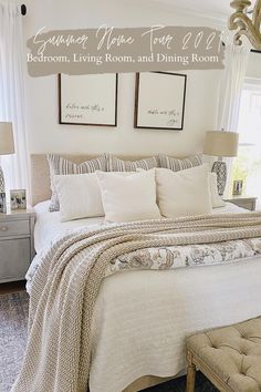 a bedroom with white bedding and two framed pictures on the wall above the bed