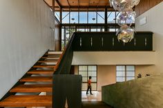 a person is walking up some stairs in a building with glass balls hanging from the ceiling