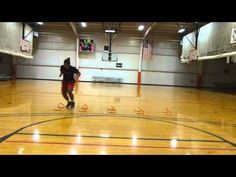 a basketball player dribbles the ball on an indoor court