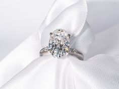 a diamond ring sitting on top of a white cloth