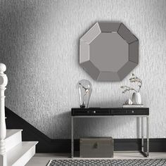 a black and white room with a mirror on the wall, rugs and stairs