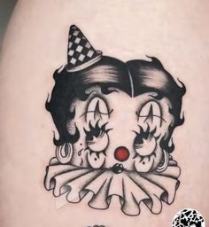 a woman's thigh with a clown tattoo on it