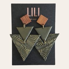 the earrings are made from wood and have triangular shapes with geometric designs on them,