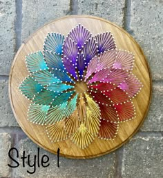 a colorful flower made out of metal wire on a wooden plaque with the words style 1 written below it