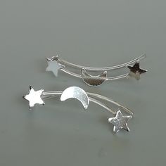 Sterling silver stars and moon ear climber/creeper. Fits most ears. Price is for TWO pieces. Dimensions: 22 x 5 mm These climbers are made of 925 hypoallergenic sterling silver. All my pieces are sent in a gift box. I can include a personal message from you if needed. You are welcome to contact me at... bhavnakwintra1956@gmail.com For more beautiful pieces from my shop, please browse 👇 TOE RINGS: https://www.etsy.com/your/shops/TheSilverGame/tools/listings/section:27020628,view:table EAR HOOPS: Handmade Adjustable Sterling Silver Ear Climbers, Handmade Sterling Silver Ear Climbers, Celestial Silver Cartilage Earrings, Silver Ear Climbers, Flower Ear, Silver Flower Earrings, Ear Climbers, Tiny Star, Silver Ear Cuff