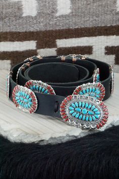 This Sleeping Beauty turquoise, coral and sterling silver squash blossom, concho belt, earrings, pin/ pendant, bracelets, and rings set was made by Navajo silversmith Justina Wilson. The back is signed JW and stamped sterling.Squash BlossomLength: 26 1/2"Naja Height: 3"Naja Width: 3"Blossom Length: 1 1/8"Blossom Width: 2 1/8" Concho Belt Belt Length: up to 60" Belt Buckle Length: 3 1/4" Belt Buckle Width: 2 1/8" Concho Length: 2 1/2" Concho Width: 1 3/4" EarringsLength: 1 1/2"Width: 1 1/8"Pin/ P Bohemian Concho Jewelry For Rodeo, Traditional Concho Jewelry For Western-themed Events, Artisan Hand-tooled Jewelry For Rodeo, Turquoise Concho Jewelry For Rodeo, Southwestern Hand Tooled Jewelry For Festivals, Bohemian Concho Jewelry For Western-themed Events, Southwestern Hand-tooled Jewelry For Ranch, Western Style Concho Jewelry Collectible, Artisan Jewelry With Concho For Western-themed Events