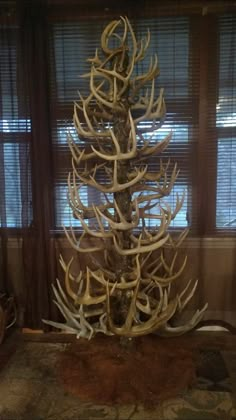 a deer antler christmas tree in front of a window