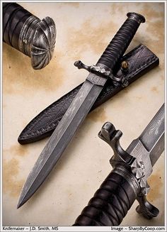 two swords are sitting next to each other on a table, one has a knife and the other has a dagger