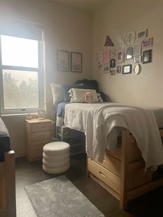 a bed room with a neatly made bed next to a large window and a rug on the floor