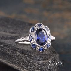 a blue stone ring sitting on top of a rock